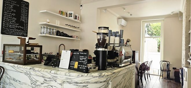 The marble counter and espresso machine, cropped below the chalkboard.
