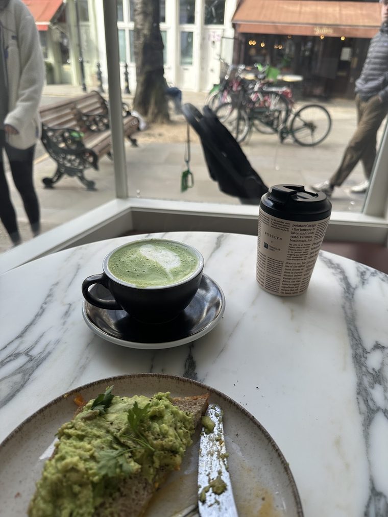 A matcha latte in a cup on a marble ledge.